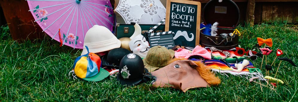 Photo booth props: hats, masks, parasols and a chalkboard sign